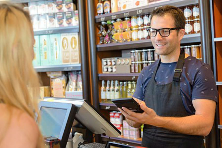 Commerçant en boutique souriant devant une cliente